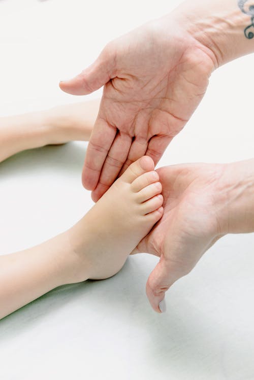 Free Person Massaging Baby Feet Stock Photo