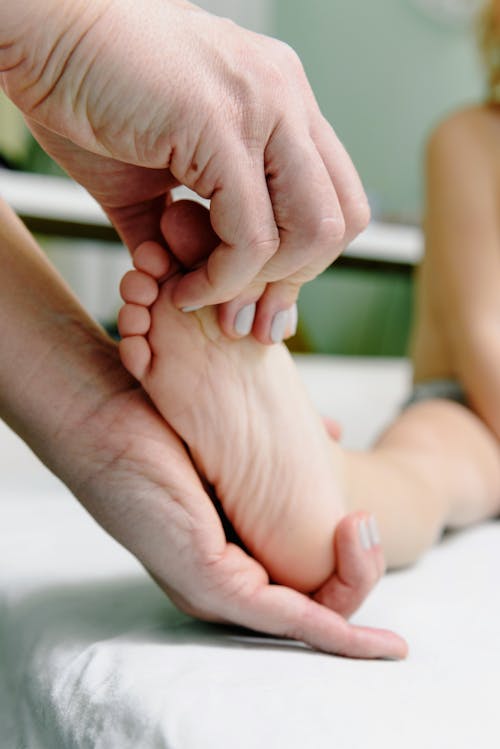 Free Person Massaging Baby Feet Stock Photo