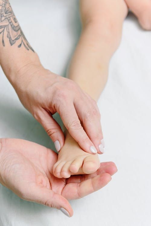 Free Person Massaging Baby Feet Stock Photo