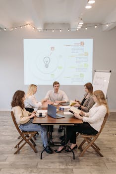 Business team collaborates during a presentation in a well-lit office setting.