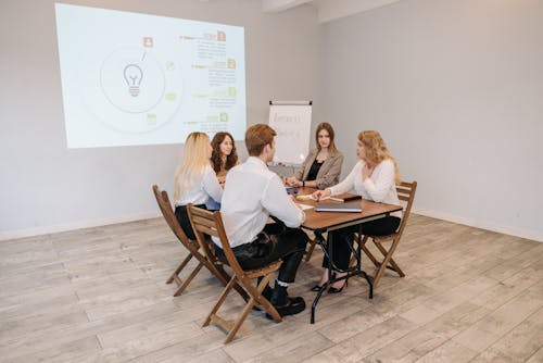 A Group of People at a Wooden Table in a Meeting