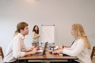 Employees Sitting Face to Face in Between the Table while Having Conversation