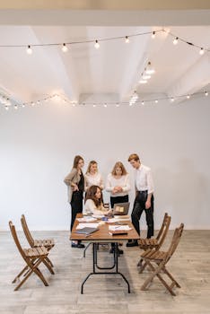 A group of professionals engaged in a collaborative meeting at a wooden table, fostering teamwork.