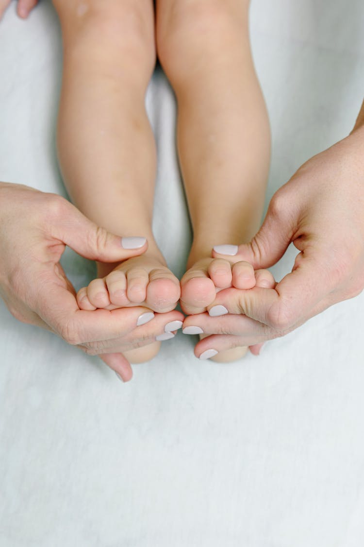 Woman Massaging Baby Body Parts