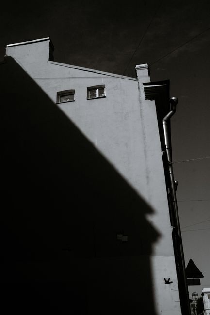 Photograph of a building showing dramatic shadows on its facade, in monochrome.