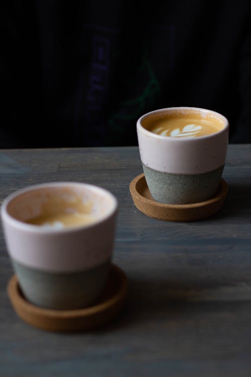 Cups with fresh aromatic cappuccino on table