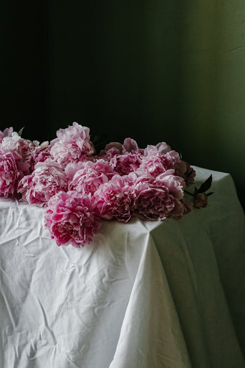 Bunch of delicate pink peonies on table