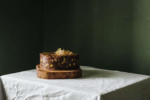 Delicious cake with topping on wooden board