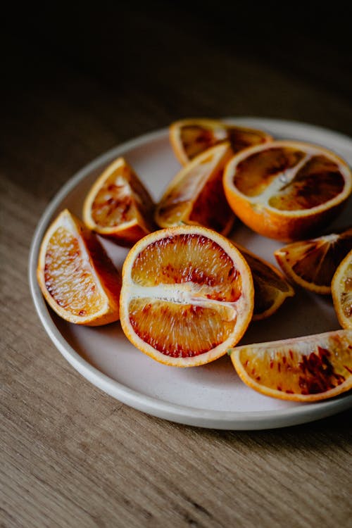 Free High angle of red oranges cut on halves and slices placed on plate Stock Photo