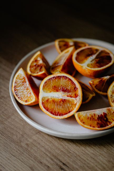 High angle of red oranges cut on halves and slices placed on plate