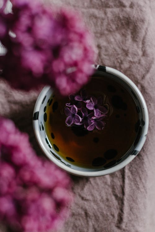 Flowers placed near tea with petals