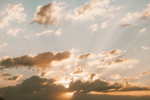Dramatic sunset sky with golden clouds and sun rays creating a picturesque scene.