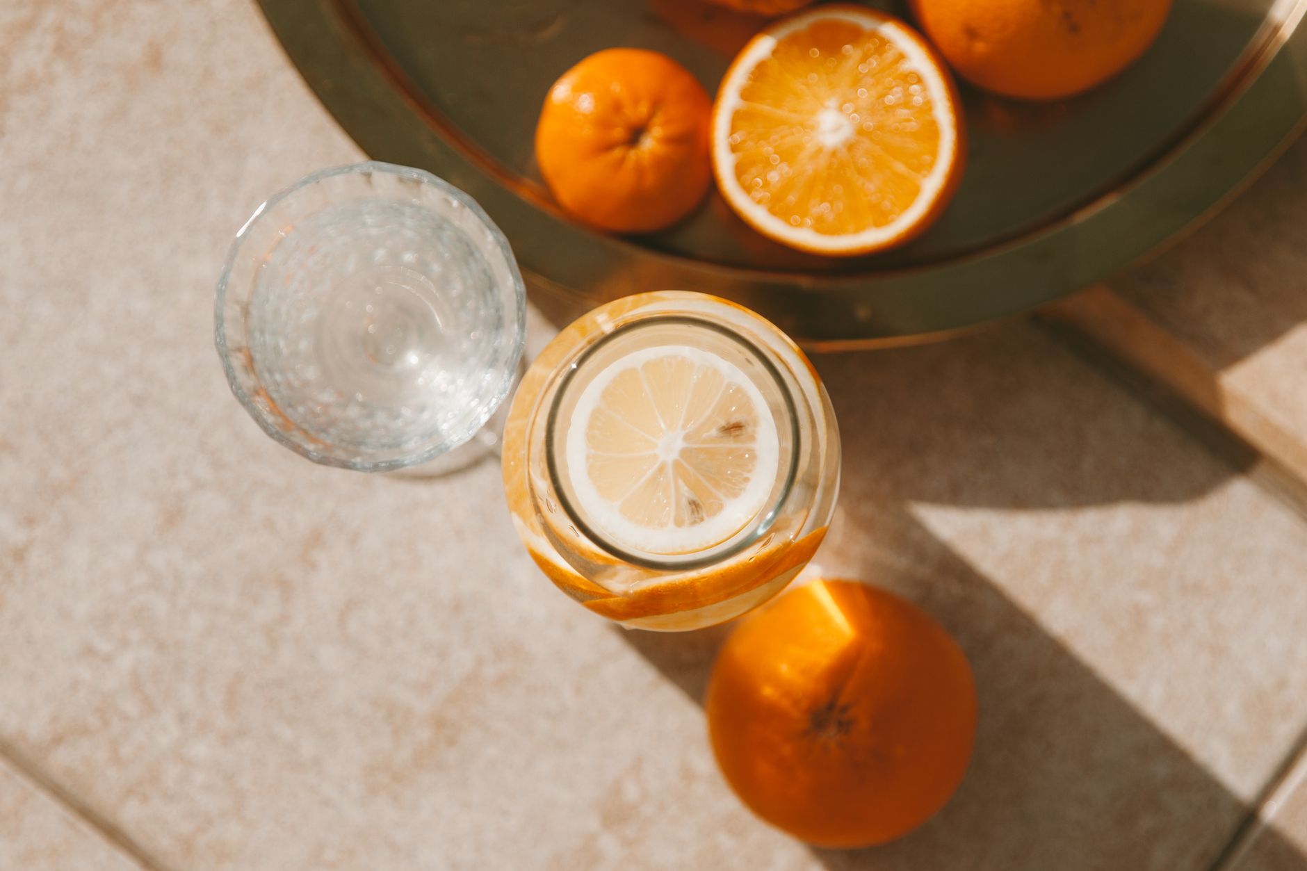 Top view of fresh citrus fruits and drink in sunlight, creating a vibrant and refreshing scene
