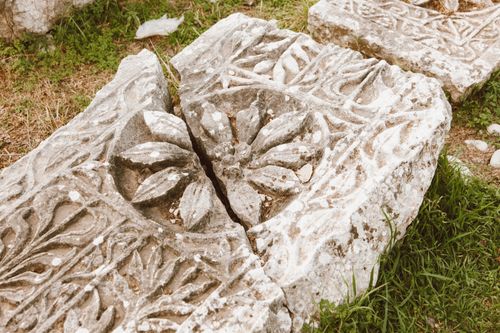 Free Close-up of a detailed ancient stone carving on a broken slab outdoors. Stock Photo