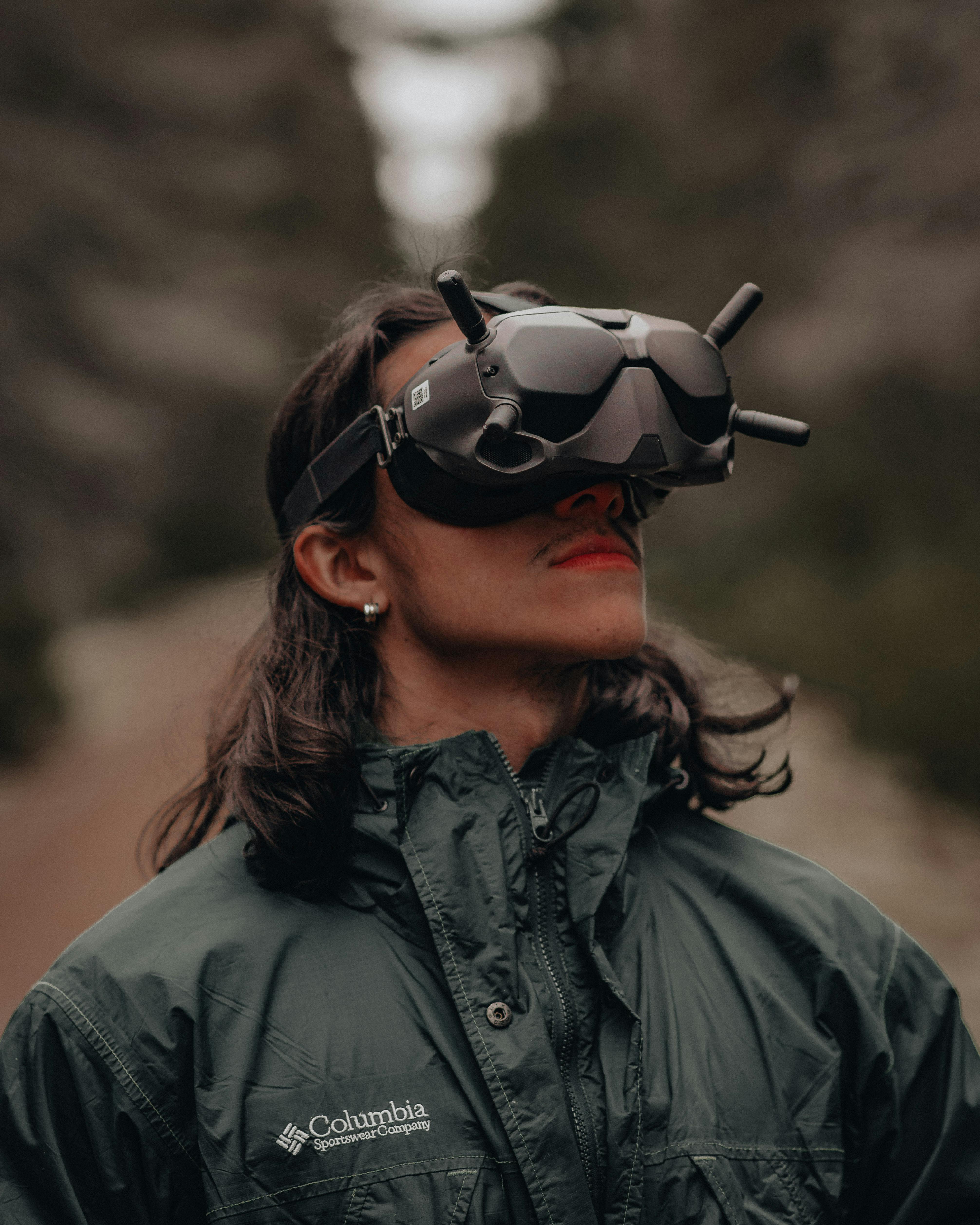 A person wearing FPV goggles enjoys the forest outdoors, showcasing adventure and technology.