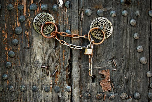 Free Padlock and Chain on an Old Wooden gate Stock Photo