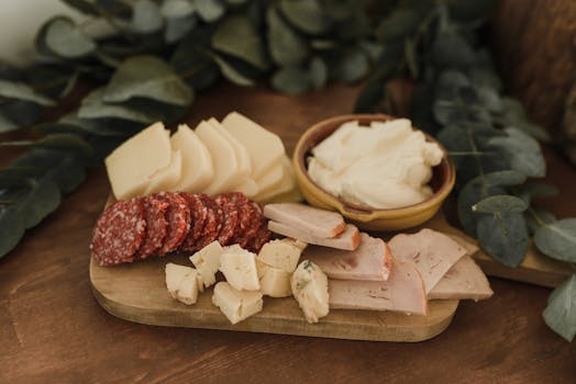 An inviting charcuterie board with salami, cheeses, and spread, perfect for gourmet gatherings.
