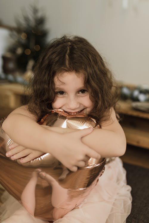 無料 茶色の木製トレイを保持している白いタンクトップの女の子 写真素材