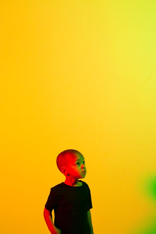 Free Vivid portrait of a young boy in front of a colorful yellow background. Stock Photo