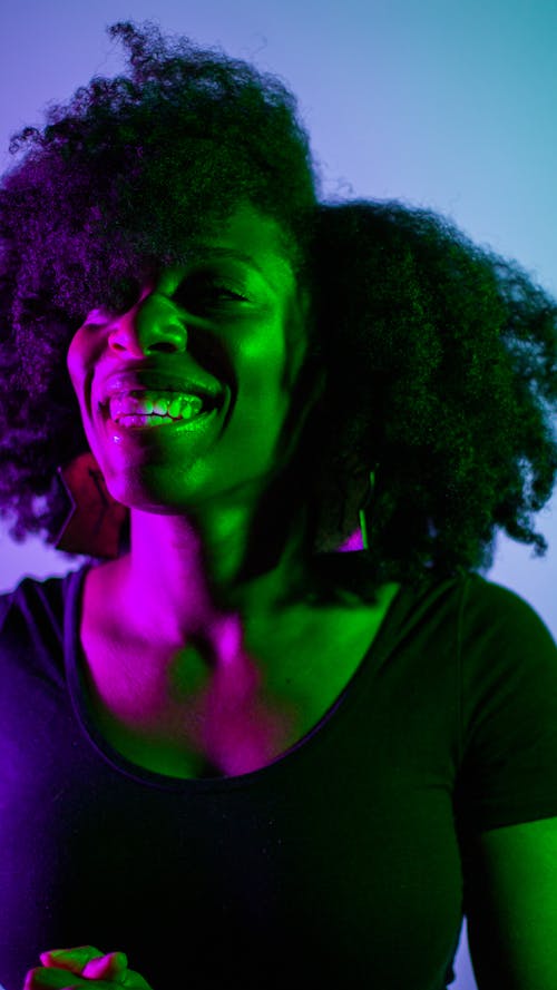 Free Portrait of a Smiling Woman in a Colorful Studio Lighting  Stock Photo