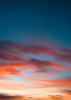 From below spectacular view of bright orange clouds floating in sky at sundown