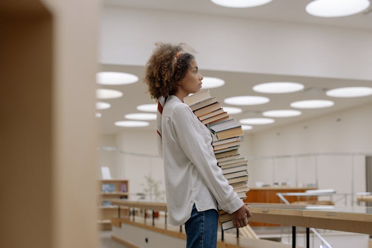 Photo Of Woman Carrying Pile Of Books 