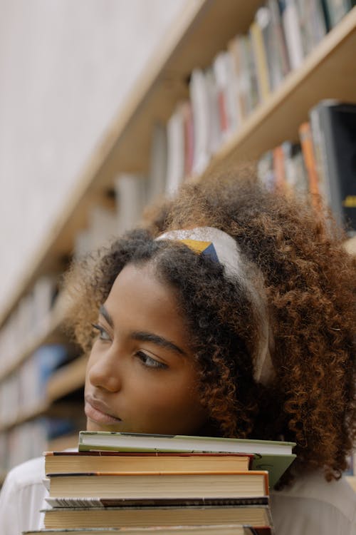 Free Photo Of Woman Leaning Her Head On Top Of Books Stock Photo