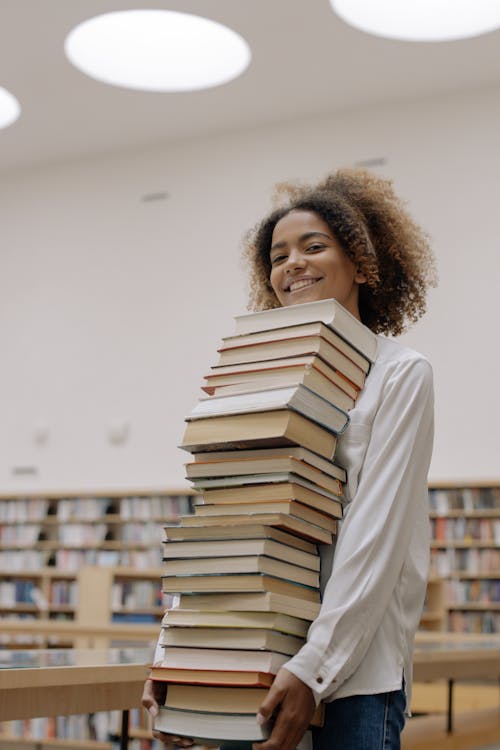 Free Photo Of Woman Carrying Bundle Of Books Stock Photo