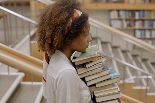 Side View Photo Of Woman Carrying Books