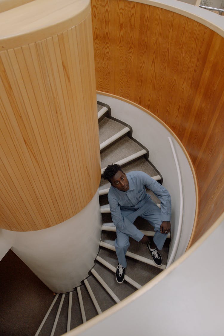 Man Sitting On A Spiral Staircase