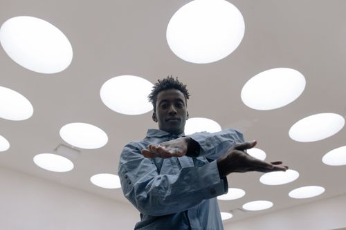 Free Stylish portrait of a man posing in a bright room with circular lights. Stock Photo