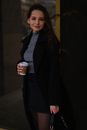 Young smiling woman in short skirt with cup of coffee
