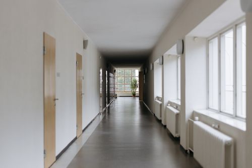 Free Spacious modern hallway with large windows and natural light reflecting off the floor. Stock Photo