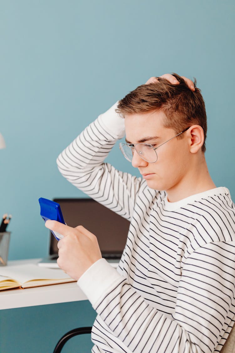 A Man Holding A Calculator