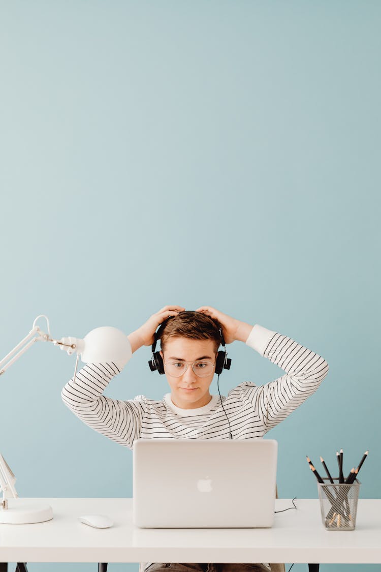 Young Man In Headphones Working On Laptop