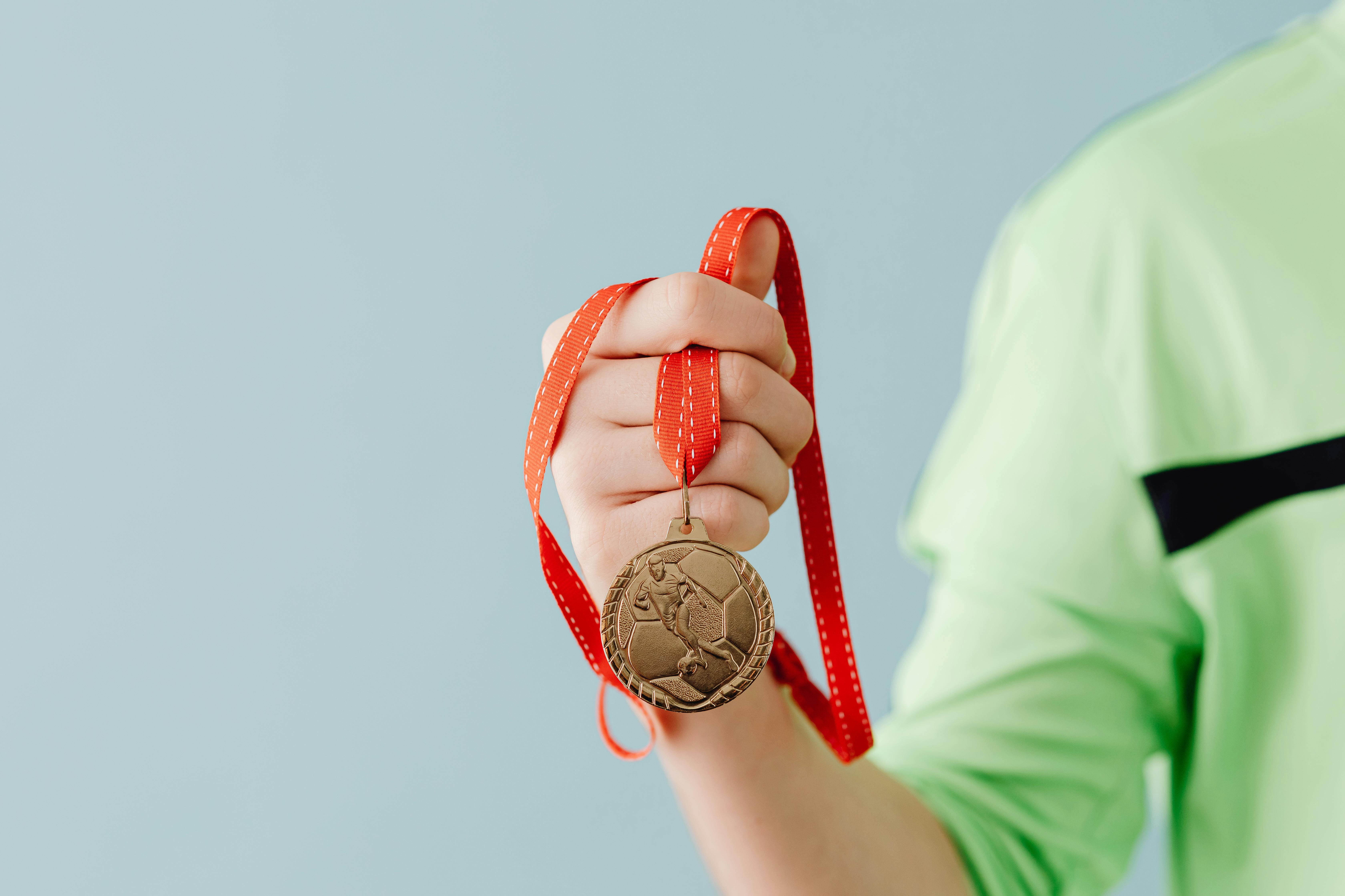 close up of a teenager holding a medal