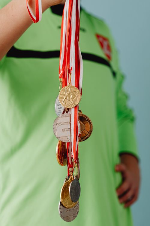 Free Teen athlete proudly displaying a collection of sports medals in a close-up shot. Stock Photo