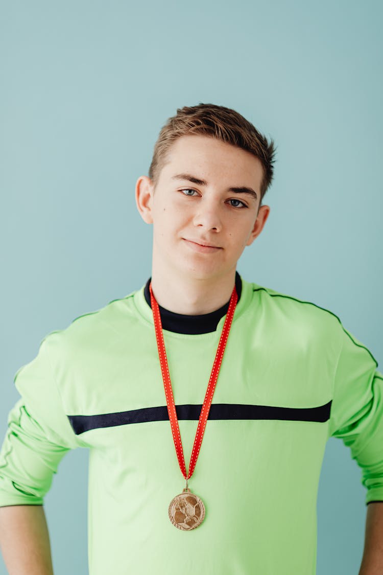 Teenage Boy In Sports Clothing With Medal