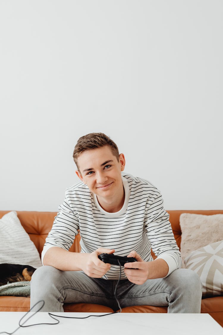 Smiling Guy Relaxing At Home Playing Console