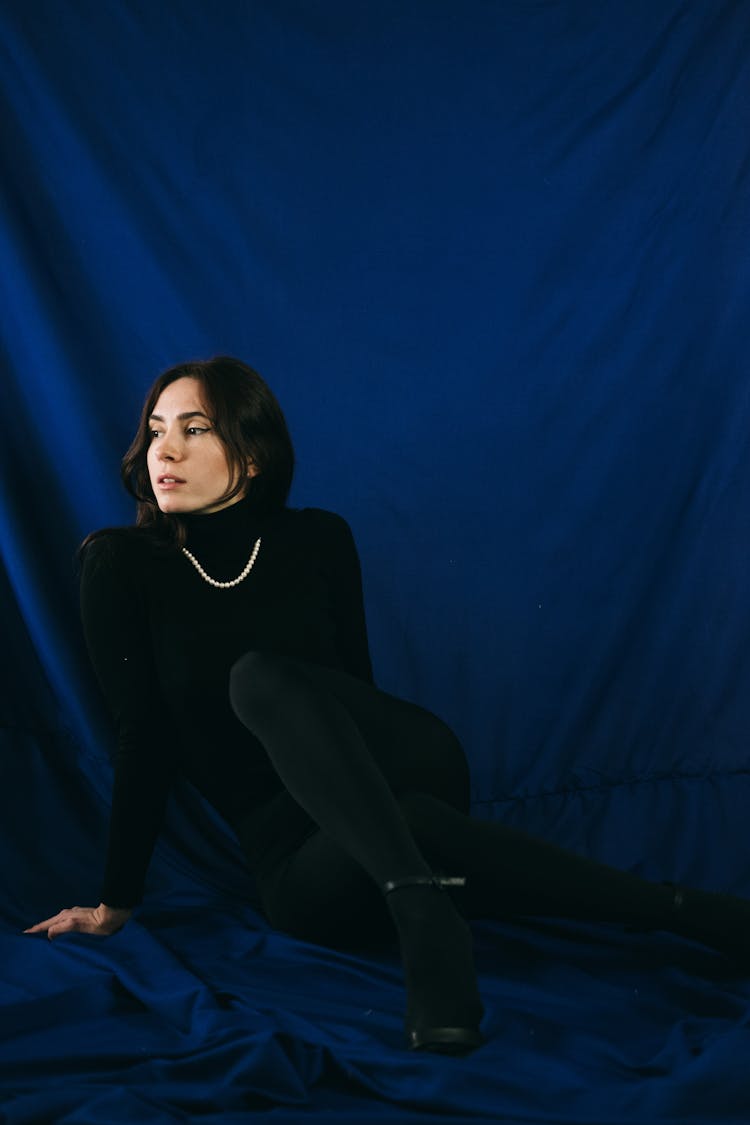 Graceful Elegant Woman On Blue Fabric Backdrop