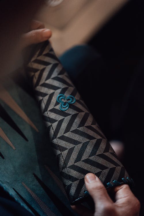 High angle of crop anonymous male opening backgammon while preparing for play at free time