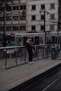 Woman browsing smartphone while waiting for transport on railway station
