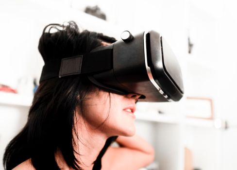 A woman wearing a VR headset, experiencing virtual reality indoors with shelves in the background.