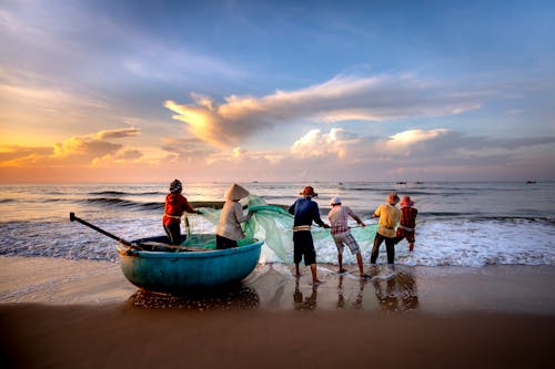 Group of Fishermen on the Sea Shore during Sunrise