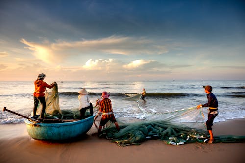 Group of Fishermen on the Sea Shore during Sunrise