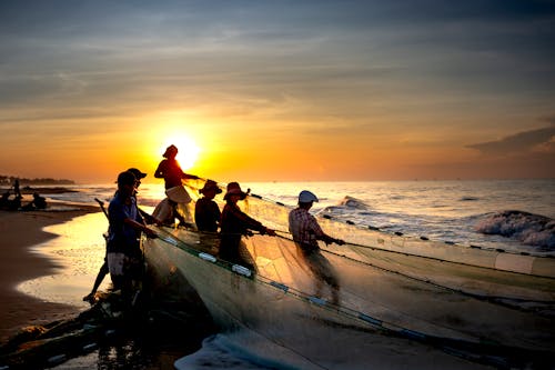 Group of Fishermen on the Sea Shore during Sunrise