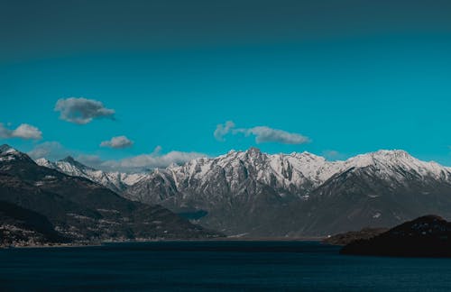 Mountain lake located in snowy valley under blue sky