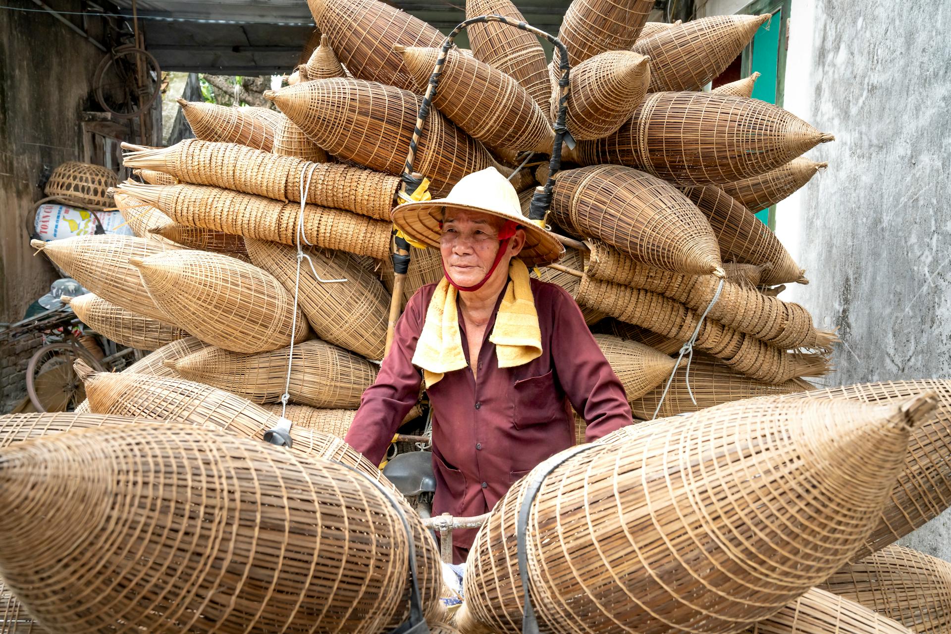 Vietnamese craftsman with bamboo fish traps in rural Hưng Yên, Vietnam.