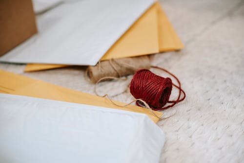 Free Woolen red and beige twine thread bobbins among envelopes Stock Photo