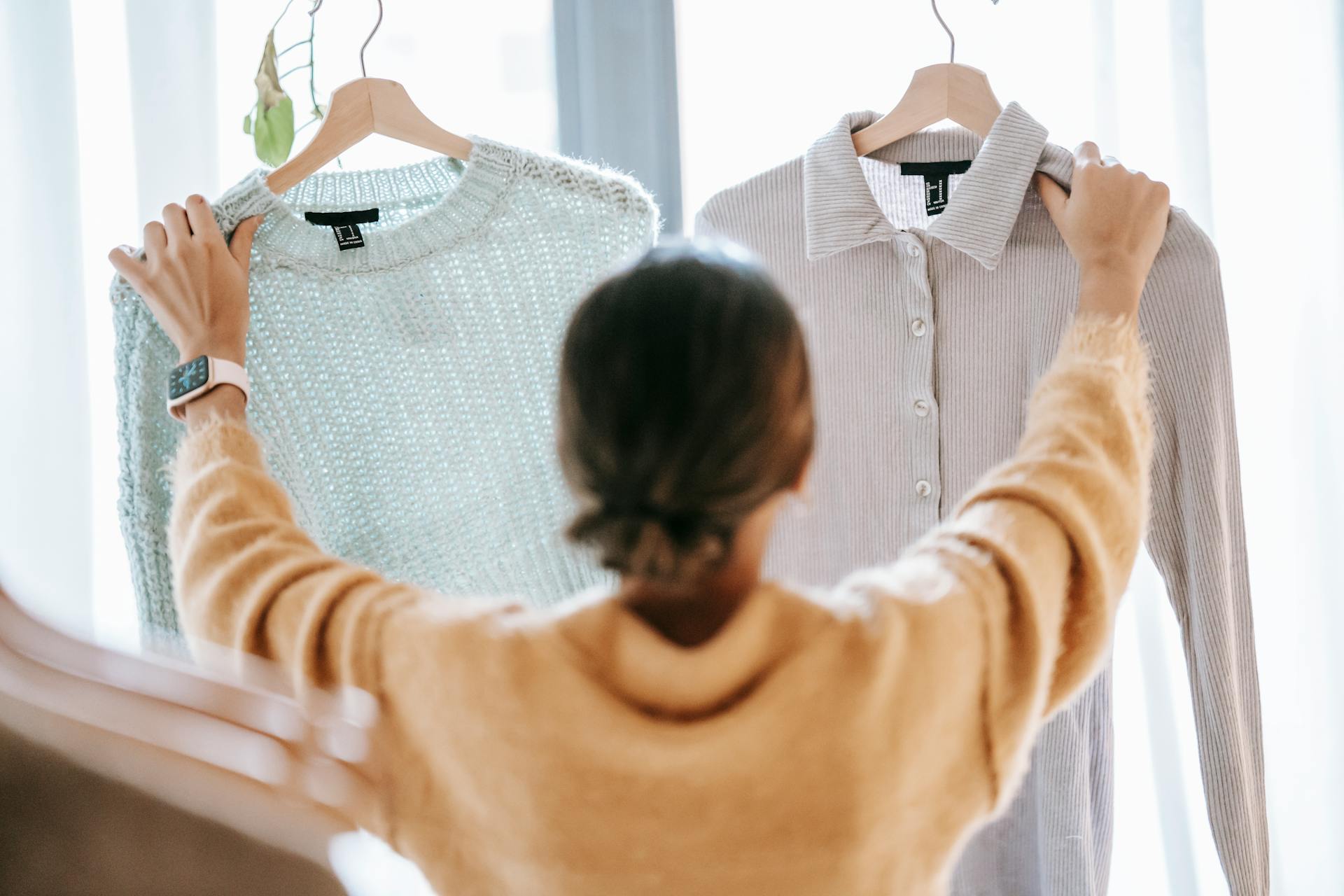 Unrecognizable woman demonstrating clothes in store